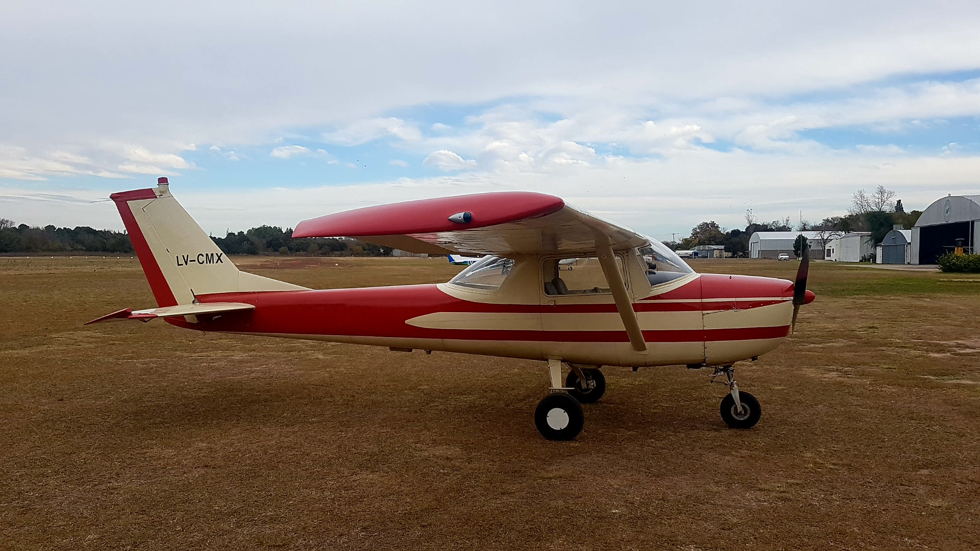 Cessna 152 · LV-CMX. Clásico de instrucción en rojo y marfil sobre la pista de tierra.