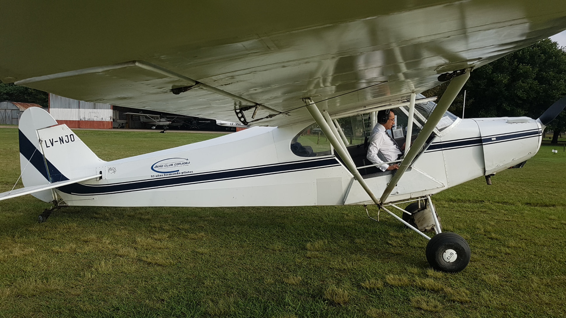 Piper PA-11 · LV-NJO. Listo en plataforma, con auriculares puestos y la lista previa al arranque.