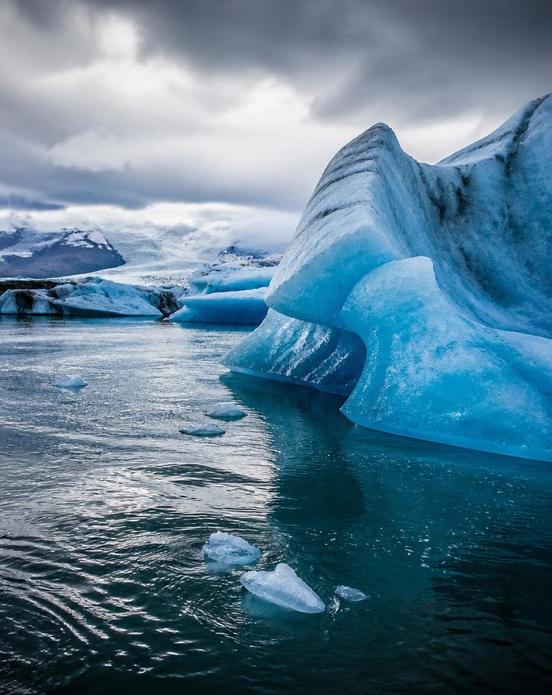 Glaciares azules vibrantes encontrándose con el agua oscura en Islandia